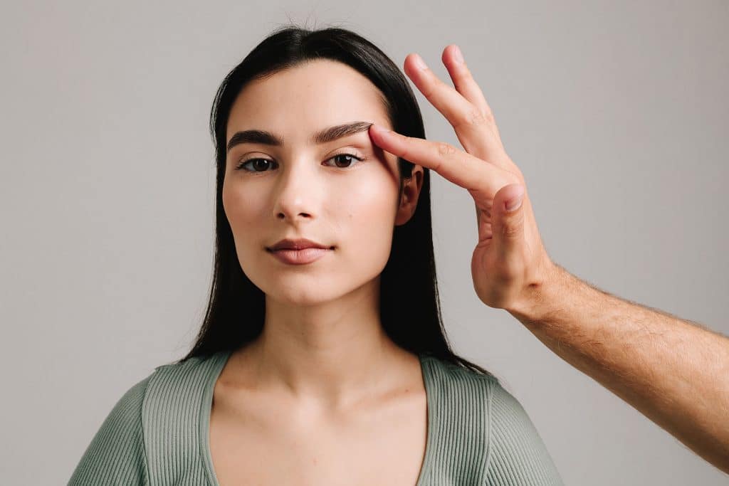 A woman with lifted eyelids, showing signs of droopy eyelids and possible ageing or health concerns - Cienna Aesthetics Medical Clinic